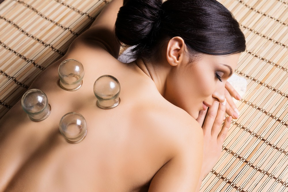 Glass cupping cups on the shoulders and upper back