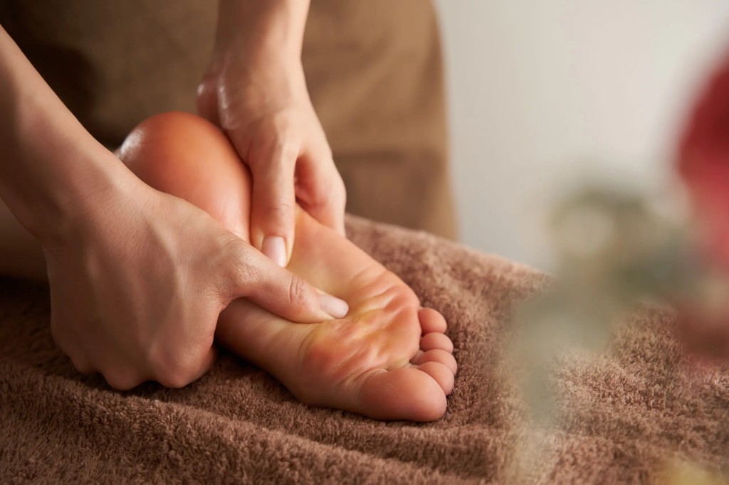 Therapeutic foot massage with focused pressure along the sole in a calm spa setting